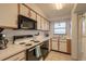 Functional kitchen featuring classic appliances, bright white cabinets, and ample counter space at 3180 Ocean Shore Blvd # 208, Ormond Beach, FL 32176