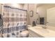 Well-lit bathroom with neutral tones and a stylish seashell-themed shower curtain at 3365 Meleto Blvd, New Smyrna Beach, FL 32168