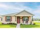 Inviting single-story home featuring a well-manicured lawn, a cozy porch with seating, and charming curb appeal at 3365 Meleto Blvd, New Smyrna Beach, FL 32168