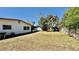 A view of the backyard features mature trees, a privacy fence, and an expansive lawn at 1119 Edith Dr, Daytona Beach, FL 32117