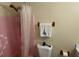 Modest bathroom featuring a white vanity and pink tiled shower/tub with a plastic shower curtain at 1119 Edith Dr, Daytona Beach, FL 32117