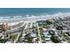 Aerial view of a beachfront community with a mix of homes, hotels, and direct beach access at 320 Due East St, New Smyrna Beach, FL 32169