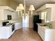 Spacious kitchen featuring white cabinets, black appliances, tile floor, and elegant chandelier lighting at 101 Braeburn Cir, Daytona Beach, FL 32114