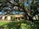 A beautifully landscaped front yard and charming home with a brick facade and mature oak trees create inviting curb appeal at 1780 Otisco Way, Winter Springs, FL 32708