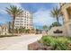 Beautiful condo building with palm trees in a landscaped setting and a decorative entrance sign at 253 Minorca Beach Way # 202, New Smyrna Beach, FL 32169
