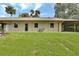 Expansive backyard with mature lawn features a covered carport, offering ample outdoor space at 2536 Paige Ave, New Smyrna Beach, FL 32168