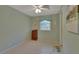 The serene bedroom features a tile floor, neutral paint, a window, and an adjacent bathroom at 2536 Paige Ave, New Smyrna Beach, FL 32168