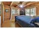 Cozy bedroom showcasing wood walls, hardwood floors, and natural light from multiple windows at 2536 Paige Ave, New Smyrna Beach, FL 32168