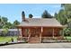 Charming log cabin featuring a covered porch, stone chimney, and landscaped front yard at 2536 Paige Ave, New Smyrna Beach, FL 32168