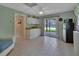 Bright kitchenette features white cabinets, a tile floor, and sliding glass door to the pool at 2536 Paige Ave, New Smyrna Beach, FL 32168