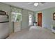 Bright kitchenette featuring white cabinets, a tile floor, window, and exterior door at 2536 Paige Ave, New Smyrna Beach, FL 32168