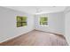 Well-lit bedroom with wood-look flooring, double door closet and two windows at 4660 Holly Rd, New Smyrna Beach, FL 32168