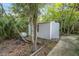 White storage shed nestled in a wooded backyard setting at 4660 Holly Rd, New Smyrna Beach, FL 32168