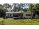 Exterior backyard of property, showing the porch and landscaped surroundings at 1949 Bayview Dr, New Smyrna Beach, FL 32168