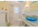 Well-lit bathroom featuring a colorful sink and wainscotting at 1949 Bayview Dr, New Smyrna Beach, FL 32168