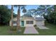 Charming yellow single-story home with a vibrant turquoise front door and an attached one car garage at 1949 Bayview Dr, New Smyrna Beach, FL 32168