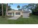 Charming yellow single-story home with a vibrant turquoise front door and an attached one car garage at 1949 Bayview Dr, New Smyrna Beach, FL 32168