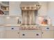 Gourmet kitchen showcasing a professional-grade stove, custom range hood, and white cabinetry at 1949 Bayview Dr, New Smyrna Beach, FL 32168