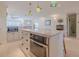 Bright kitchen featuring a marble island, custom cabinetry, and unique pendant lighting at 1949 Bayview Dr, New Smyrna Beach, FL 32168