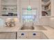 Well-appointed kitchen featuring a stainless steel sink, marble countertops, and ample shelving at 1949 Bayview Dr, New Smyrna Beach, FL 32168