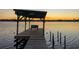 Picturesque sunset view from a wooden pier with a bench overlooking the tranquil water at 1949 Bayview Dr, New Smyrna Beach, FL 32168