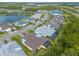 An aerial shot of houses nestled in a scenic neighborhood near a tranquil pond and lush greenery, offering a serene living environment at 306 Coral Reef Way, Daytona Beach, FL 32124