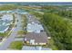 Aerial shot of a neighborhood showcasing a row of houses with green lawns and scenic views of a pond and wooded area at 306 Coral Reef Way, Daytona Beach, FL 32124