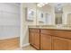 Bathroom features a double sink vanity with granite countertops and access to a walk-in closet at 306 Coral Reef Way, Daytona Beach, FL 32124