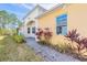 Welcoming walkway leads to a charming home exterior with beautiful landscaping and natural light at 306 Coral Reef Way, Daytona Beach, FL 32124