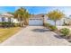 Charming home featuring a paver driveway, two-car garage, and well-maintained landscaping at 306 Coral Reef Way, Daytona Beach, FL 32124