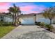 Charming home featuring a paver driveway, two-car garage, and well-maintained landscaping at 306 Coral Reef Way, Daytona Beach, FL 32124