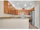 Well-lit kitchen features granite counters, stainless steel fridge, and hardwood cabinetry at 306 Coral Reef Way, Daytona Beach, FL 32124