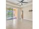 Open living room with tile flooring, a ceiling fan, and sliding glass doors to the patio at 306 Coral Reef Way, Daytona Beach, FL 32124