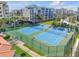 Aerial perspective of vibrant blue community tennis courts, surrounded by lush landscaping on a sunny day at 5300 S Atlantic Ave # 8-303, New Smyrna Beach, FL 32169