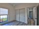 Well-lit bedroom featuring window, double doors and grey flooring at 1428 Willow Oak Dr, Edgewater, FL 32132