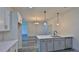 Kitchen island with sink, white cabinets, and modern lighting at 1428 Willow Oak Dr, Edgewater, FL 32132