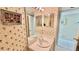 Bathroom with a single sink vanity, mirror, and tropical themed wallpaper at 2700 N Peninsula Ave # 322, New Smyrna Beach, FL 32169