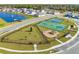 Aerial view of community dog park, basketball and pickleball courts, and playground near lake at 5226 Hophorn Dr, Edgewater, FL 32141