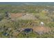 Aerial view showing home, pond, and surrounding land at 1035 S State Road 415, New Smyrna Beach, FL 32168