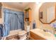 Bathroom with light blue shower curtain, wood vanity, and framed mirror at 1035 S State Road 415, New Smyrna Beach, FL 32168