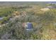 Aerial view of a house with a pool in a wooded setting at 1371 Melonie Trl, New Smyrna Beach, FL 32168