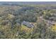 Aerial view of a house with a pool, set amongst a backdrop of trees at 1371 Melonie Trl, New Smyrna Beach, FL 32168