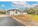 White house with a three-car garage and landscaped yard at 1371 Melonie Trl, New Smyrna Beach, FL 32168