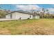 Back exterior view of house showing landscaping and backyard at 1371 Melonie Trl, New Smyrna Beach, FL 32168