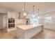 Modern white kitchen with large island, stainless steel appliances, and hardwood floors at 1371 Melonie Trl, New Smyrna Beach, FL 32168