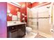 Bathroom with dark vanity, shower, and red walls at 3447 Poneta Ave, New Smyrna Beach, FL 32168