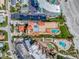 Aerial view of condos showing rooftop pool, landscaping, and parking at 701 N Atlantic Ave # 202, New Smyrna Beach, FL 32169