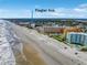 Aerial view showcasing beachfront condos with pools, along the sandy beach near Flagler Ave, under a clear blue sky at 701 N Atlantic Ave # 202, New Smyrna Beach, FL 32169