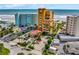 Aerial view of condo building with ocean views, palm trees, and ample parking at 701 N Atlantic Ave # 202, New Smyrna Beach, FL 32169