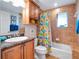 Cozy bathroom with a tub, patterned shower curtain, and granite countertop sink at 701 N Atlantic Ave # 202, New Smyrna Beach, FL 32169